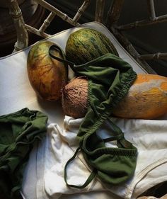 various fruits and vegetables are sitting on a table cloth, including watermelon, cantaloupe, and melons