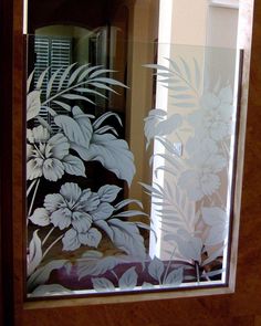 a glass door with flowers and leaves etched on it