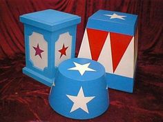 three boxes with stars on them sitting on a red cloth