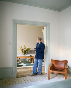 a woman standing in front of a door looking at her cell phone