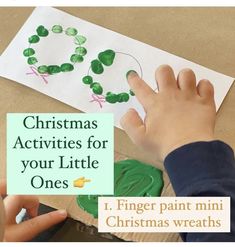 a child's hand making a christmas wreath out of paper with the words finger paint on it