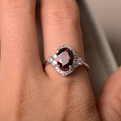 This halo ring features a 7*9mm oval cut natural garnet and sterling silver finished with rhodium. Customization is available. It is made by hand, and it will take about 7 days to finish the ring after your payment is completed. Any question, just let me know. :) My shop homepage: https://www.etsy.com/shop/LuoJewelry?ref=l2-shopheader-name Garnet Ring Engagement, January Birthstone Rings, Garnet Engagement Ring, Red Garnet Ring, Cushion Cut Engagement, Spinel Ring, Natural Gemstone Ring, January Birthstone, Garnet Ring