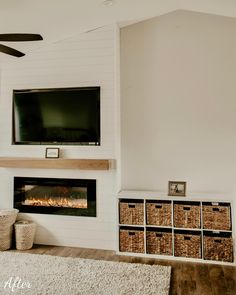 a living room with a fireplace, television and baskets on the floor in front of it