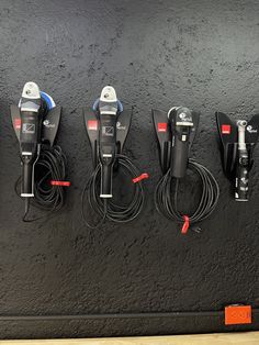 there are four different types of electrical cords attached to the side of a black wall