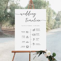 an easel with a sign on it that says, wedding time line and flowers