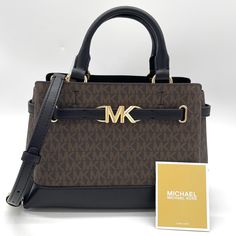 Brand New With Tag Michael Kors Reed Small Satchel Crossbody Bag Satchel Color: Brown/Black Logo-Print Canvas/Faux Leather 74% Coated Canvas/19% Polyester/7% Polyurethane Trim: 60% Polyurethane/20% Cotton/20% Polyester Gold-Tone Hardware 10.5”W X 7.5”H X 4.25”D Handle Drop: 4” Adjustable Strap: 18.5”-22.25” Interior Details: Back Zip Pocket, Front Slip Pocket Lining: 100% Polyester Zip Fastening Dust Bag Not Included Imported Brown Double Handle Shoulder Bag With Logo, Michael Kors Evening Bag With Logo, Brown Top Handle Satchel With Logo, Chic Brown Bag With Logo, Rectangular Brown Satchel With Logo, Brown Rectangular Satchel With Logo, Michael Kors Top Handle Shoulder Bag With Logo, Brown Satchel Bag With Logo, Brown Crossbody Bag With Logo