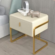 a small white table with a drawer on it and a toy elephant sitting on top of it