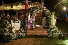 an outdoor ceremony with flowers and greenery on the stage for guests to sit down