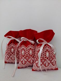 three red bags with white lace on them