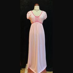 Vintage pastel pink long nightgown.  Shoulder cap sleeves  Magenta trim around neckline and bust.  Three magenta buttons down the bust.  This beauty had two tiny holes on the front in which I put two tiny floral appliqués to cover.  To sweet not to list.  Women's size Large Please ask for measurements if interested.  Thank you. Pink V-neck Nightgown With Lace Trim, Vintage Pink Sleep Dresses, Pink Vintage Sleep Dress, Pink Lace Trim Dresses For Bedtime, Fitted Pink Nightgown For Sleep, Vintage Pink V-neck Nightgown, Pink Fitted V-neck Nightgown, Pink Short Sleeve Sleepwear With Lace Trim, Feminine Pink Short Sleeve Nightgown