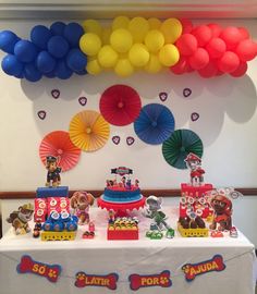 a table topped with lots of toys and balloons