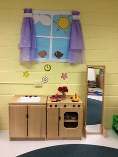 a child's playroom with toys and decorations on the wall, including a mirror