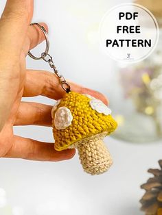 a hand holding a small crocheted mushroom keychain