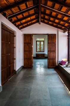 an empty room with wooden doors and windows