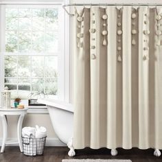 a bathroom with a tub, shower curtain and rug in front of the bathtub