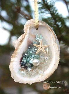 an ornament hanging from a tree with sea glass and starfish on it