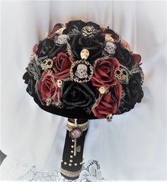 a bridal bouquet with black and red roses, diapered brooches