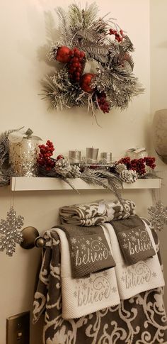 a christmas wreath is hung on the wall above a mantle with towels and other holiday decorations