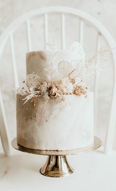 a white cake sitting on top of a metal stand