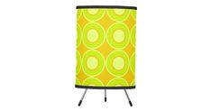 a yellow and green lamp shade with circles on the bottom, in front of a white background