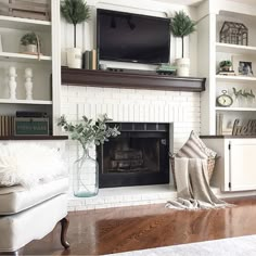 a living room filled with furniture and a flat screen tv mounted above a fire place