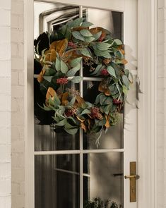 a wreath hanging on the front door of a house