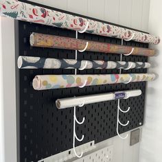 a wall mounted coat rack with umbrellas hanging from it's sides and hooks