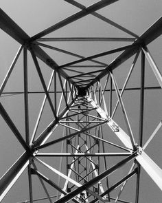 black and white photograph of the top of an electrical tower with wires running through it