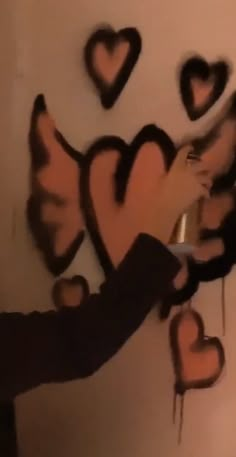 someone is painting hearts on the wall with paintbrushes and glue to decorate it