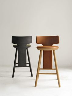 two stools in different colors, one is black and the other has brown leather