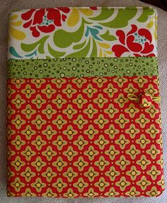 a notebook covered in colorful fabric with flowers on the front and bottom cover, sitting on a table