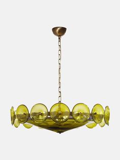 a yellow chandelier hanging from the ceiling with many glass balls on each light fixture