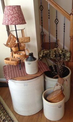 three buckets are sitting on the floor next to a table with flowers in them