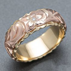 a gold wedding band with flowers on it