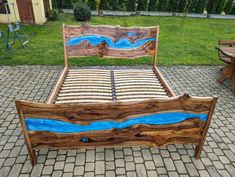 a bed made out of wood with blue paint on the headboard and foot board