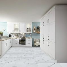 a kitchen with white cabinets and marble flooring in the center, along with an oven