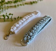 two crocheted key fobs sitting next to each other on a table