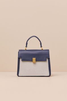 A considered cutie like you will find a million ways to style the Poised Intention Navy and White Handbag! Sleek faux leather shapes this stylish bag that has a flat bottom and a satchel-inspired silhouette with woven panels at the front and back, a flexible top handle, and a top flap with a locking clasp. Roomy interior boasts a zippered sidewall pocket, a second sidewall compartment, and an optional shoulder strap for crossbody wear. Gold-toned hardware throughout. Lined. Bag Measures 8" Wide, Navy Handbag, Bag Lock, White Handbag, Stylish Bag, Business Outfits, Handle Bag, Dublin, Top Handle, Navy And White