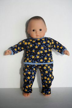 a baby doll is posed on a white surface