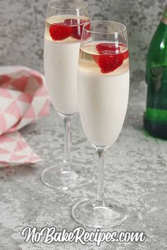 two glasses filled with champagne and topped with strawberries