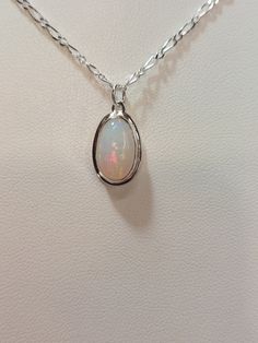 "Multi color crystal opal set in sterling silver on an 18\" Figaro style chain.  This stone has the entire spectrum of the rainbow & shows very good fire from all angles. Beautiful stone." Silver Opal Cabochon Necklace, Silver Opal Oval Pendant Jewelry, Silver Opal Oval Necklace, Silver Opal Necklace With Oval Pendant, Silver Ethiopian Opal Round Jewelry, Oval Opal Necklace In White Gold, White Gold Opal Oval Necklace, White Gold Opal Necklace With Oval Shape, Silver Ethiopian Opal Birthstone Jewelry