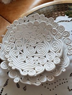 a white decorative bowl sitting on top of a table