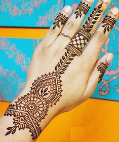 a woman's hand with henna tattoos on it