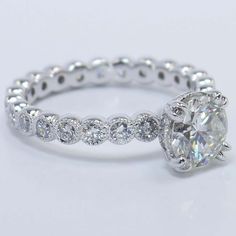 a white gold ring with an oval cut diamond in the center and side stones on each band