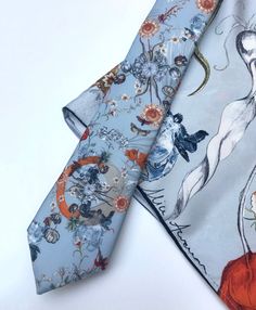 An unusual Silk Twill Tie and coordinating pocket square or little scarf with x-ray crab and tulip design. The 'Evolution' Tie and pocket square with a pale blue ground, features vintage style illustrations created by hand and digitally printed onto high quality silk. The unique design was inspired by the infinite complexities of nature and the fascinating theory of evolution with details including scientific illustration style tulips and x-ray image of a crab, moths and pineapples. The colour p Elegant Summer Handkerchiefs As Gifts, Rectangular Pocket Square As A Gift, Blue Tie With Pocket Square As Gift, Blue Pocket Square For Wedding, Elegant Formal Summer Handkerchiefs, Blue Ties With Pocket Square For Wedding, Blue Ties And Pocket Square For Groom, Blue Tie With Pocket Square For Groom, Elegant Blue Pocket Square As Gift