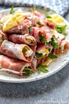 a white plate topped with meat and veggies on top of a blue table cloth