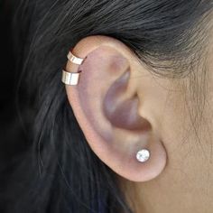 an ear piercing with two gold bars on the top and one silver bar on the bottom