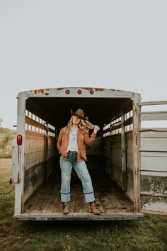 a woman standing in the back of a truck