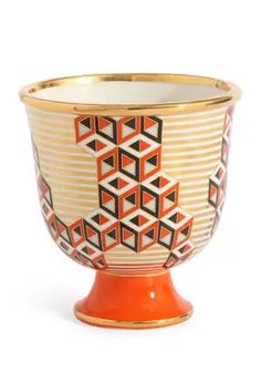 an orange and white vase with geometric designs