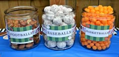 three glass jars filled with candy and candies on top of a blue table cloth